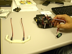 距離センサーを繋げたロボットカー。<br>左に3Dプリンターで作成したバンパー。<br>LEDが2個取り付けられている
