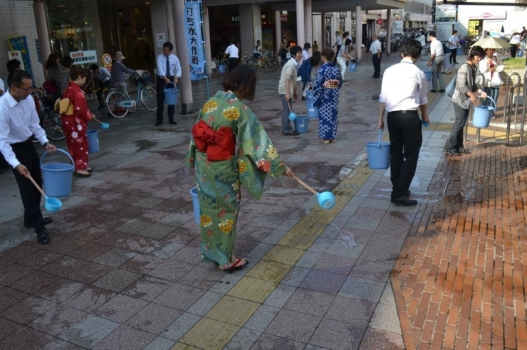 参加者の皆さんが一斉に古川橋のあつ～い地面に水を打ちつけます！