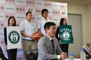 新チーム名「西宮ストークス」を発表する田中浩一代表。<br>後ろはコーチ・主将・チアの皆さん。