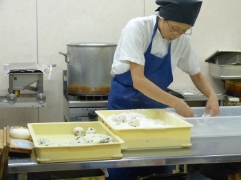 餅に餡を入れ込む作業をしています。