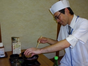 ゆず酢をかけて、うどんを混ぜる柿本料理長