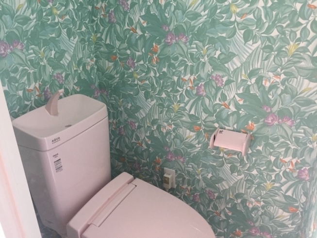 ピンクの洋便器とエスニックな雰囲気の壁紙「ひとときでもハワイを感じたいトイレのリフォーム」