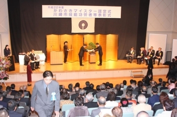 阿部市長（ステージ中央左）から表彰状を受け取る優秀青年技能の受賞者