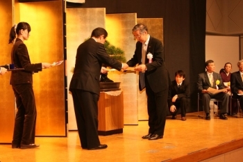 阿部市長から認定証を授与される製菓技能士の横溝春雄さん（右）