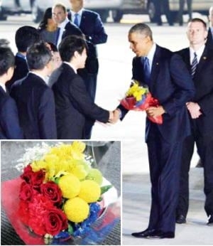 花束を手に、迎えた関係者と握手する<br>オバマ大統領（右から２人目）<br>＝２５日、中部国際空港で（愛知県提供）