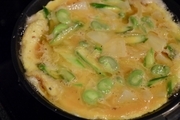 【5】フライパンをペーパータオルなどで拭いて綺麗にし、オリーブオイル大さじ１を弱めの中火で熱する。しっかり温まったら、（5）の卵液を流し入れる。<br>フライパンの面がこんがりと色づくまで焼く。