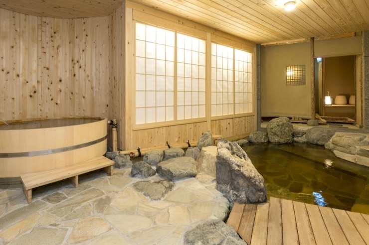 『天然温泉岩風呂』翠風荘の一階の天然温泉岩風呂。半露天となっており開放感のある空間を演出しています。ヒノキ風呂、岩風呂ともにかけ流しとなっています。