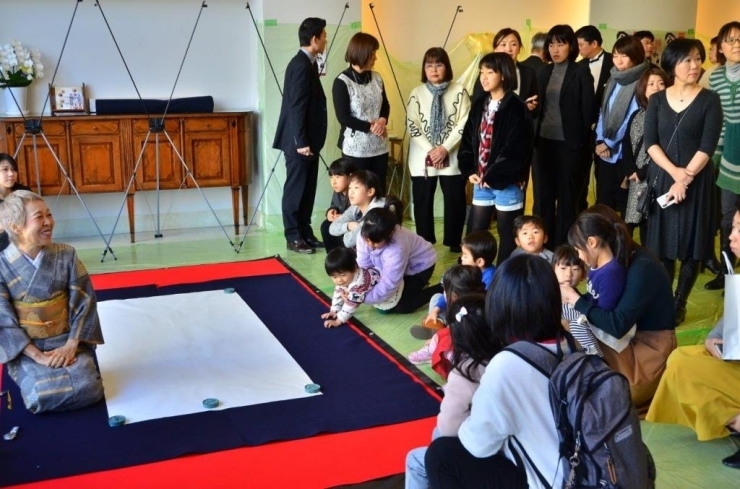 子供たちは最前列で「書道ライブ」を見学します