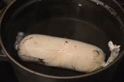【3】大きめの保温性の高い鍋に湯を沸かす。沸騰したら中火にかけたまま、（4）のラップに巻いた鶏肉を入れる。一瞬温度が下がるが、再び沸騰したら30秒そのまま茹で、火を止めて蓋をして1時間置く。鍋から取り出し、冷蔵庫か氷水で冷やす。