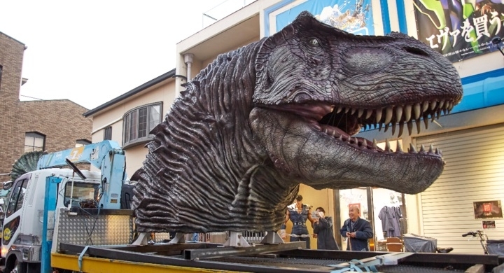 トラックの荷台に乗せられる巨大なティラノサウルス