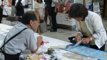 友禅染の魅力を伝える石渡さん。お客様の会話もはずみます