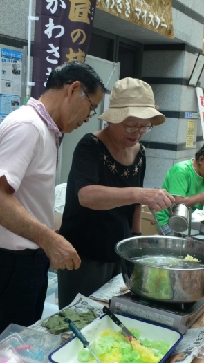 見物客の希望に応えて、食品サンプルの作り方を指導する田中さん