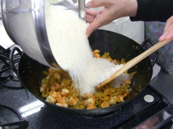 ３.の素材を炒めたら洗った米を加えます