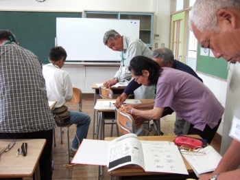 道具の使い方のうち、ロープの結び方について悪戦苦闘する受講生＝都市緑化植物園