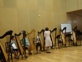 まずは練習。オーケストラスタジオで初めて触るハープにみんな不安そう・・・まずは、椅子の座り方から！