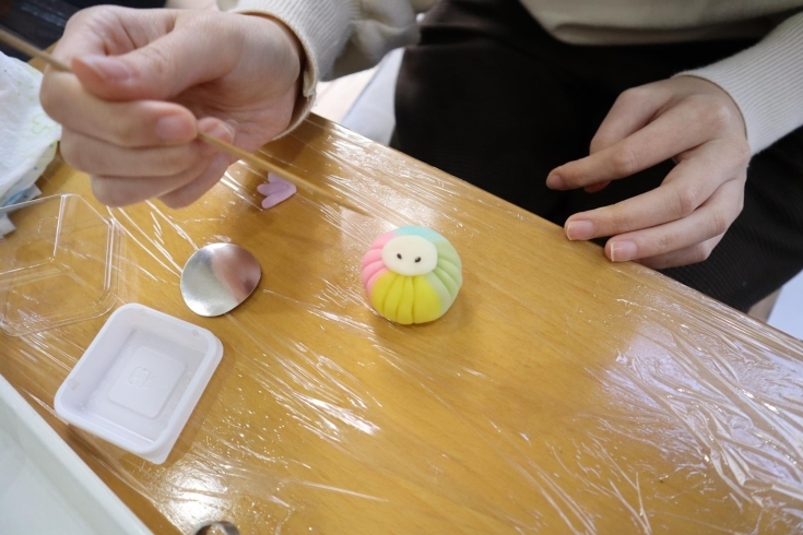 和菓子(アマビエ)の目を串でそっと乗せます「和菓子作り体験に挑戦！in紫香庵」