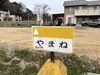 小さな坂を下りると目に入るはず「やまねへの道　The Road to Yamane」