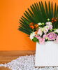 オレンジの壁に合わせてオレンジ色の花をチョイス「フレッシュフラワーディスプレイ」