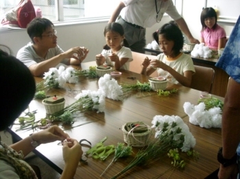 カーネーションを使って楽しそうにプードルを作る子供たち