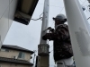 看板の柱を塗装する様子「国府印刷社-看板修理工事」