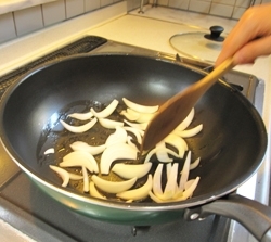 温めたフライパン（鍋）にオリーブ油を加え、玉ねぎを炒める。玉ねぎが半透明になったら赤ピーマンを加えて炒める。