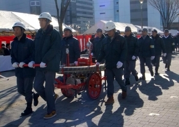 手引き可搬ポンプを引いて行進する市民消化隊