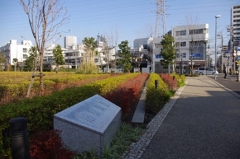 駅前のマンション前の歩道には「東海道」と書かれた石があり、その周りには彩りよく植えられた植木がある。<br>