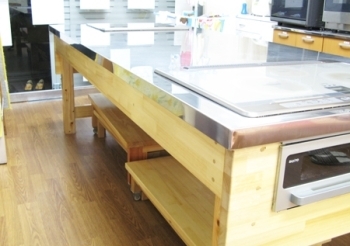 大工さんが工夫して作った調理台。<br>ＩＨコンロが組み込まれ、踏み台が年齢や背丈に応じて立てるように、調整されている。