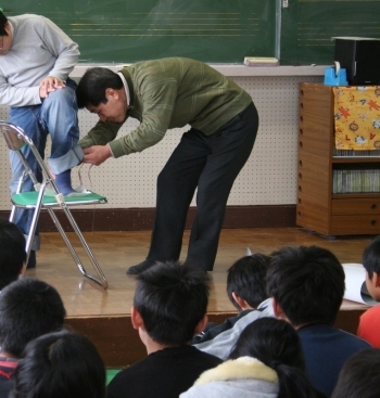 生徒の足を測定する吉田さん