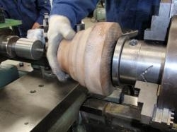 旋盤機に製品を形どった木型を取り付けます。木型で型を作ってしまえばどんな形の製品も製作することができます