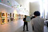 備北民報さんの取材に応じる阿部さん「「まいぷれ新見市」掲載店・あべ写真館さんの写真展に伺いました」