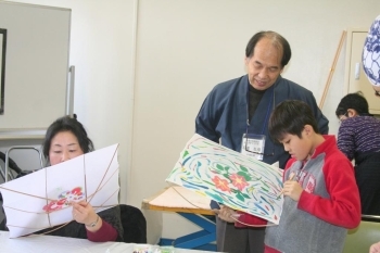 子どもたちに「自由な発想で好きなように描こう」と指導する石渡さん。