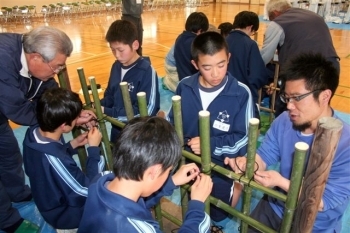 「四つ目垣」の竹の結び方をマンツーマンで教えてもらう有馬中生徒。