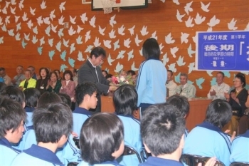 校長先生にフラワーアレンジメントの作品がプレゼントされました(生田中)。