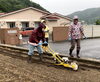 小雨の中、合羽姿で種まき機を使って種まき「ヒマワリの種まきをしました。」