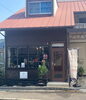 お店正面。旗の右側がカーポート。「お店の外観・アクセス・店内紹介！岡山かばんへようこそ」