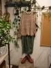 「ベージュチェックシャツ×透かし編みベストの秋コーデと温かみある店内ディスプレイ」
