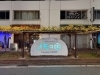 大阪大開郵便局の近くの藤棚の下にあります。「【福島区でアフター万博】大阪・関西万博「ノモの国」パビリオンの館名サインが大開に登場！」