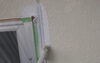「窓まわりの養生と際まで丁寧に行う外壁の下塗り作業」