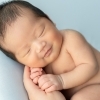 ママの手に包まれた、はじめての笑顔