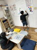 始めは習字を楽しんでいたが、いつの間にか外国人スタッフに漢字を教える側に。「毎日イベント「習字に挑戦」紹介」