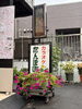 「季節の花と看板がお迎えする、たんぽぽの店先のご紹介」