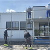事務所外壁の掃除と、実習生への丁寧な指導の様子