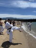 青い空と海を背景に1000本蹴り「ウェルピア伊予で夏季合宿！海で1000本突き・1000本蹴りも体験しました」