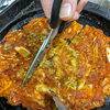 鉄板で焼き上げる 김치지지미をお酒と一緒に