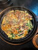 「熱々の鉄板で香ばしく焼き上げるエビとイカの해물파전（海鮮チヂミ）」