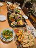 「気兼ねなく集まり、笑顔が広がるひととき。食卓を囲んでみんなで楽しむ自宅ホームパーティーのひとコマ」