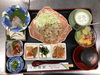 「香ばしい豚皿にお刺身や多彩な小鉢が並ぶ家庭的でほっとする本日の日替わり御膳」