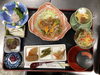 「香ばしい豚焼肉にお刺身や多彩な小鉢が並ぶ家庭的でほっとする本日の日替わり定食」