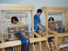【織物工房・体験実習室】<br>織り機を使い、手織の良さを生かした新たな工芸品を制作し、その技術を体験できます。